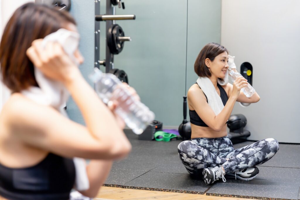 トレーニング中水を飲む女性